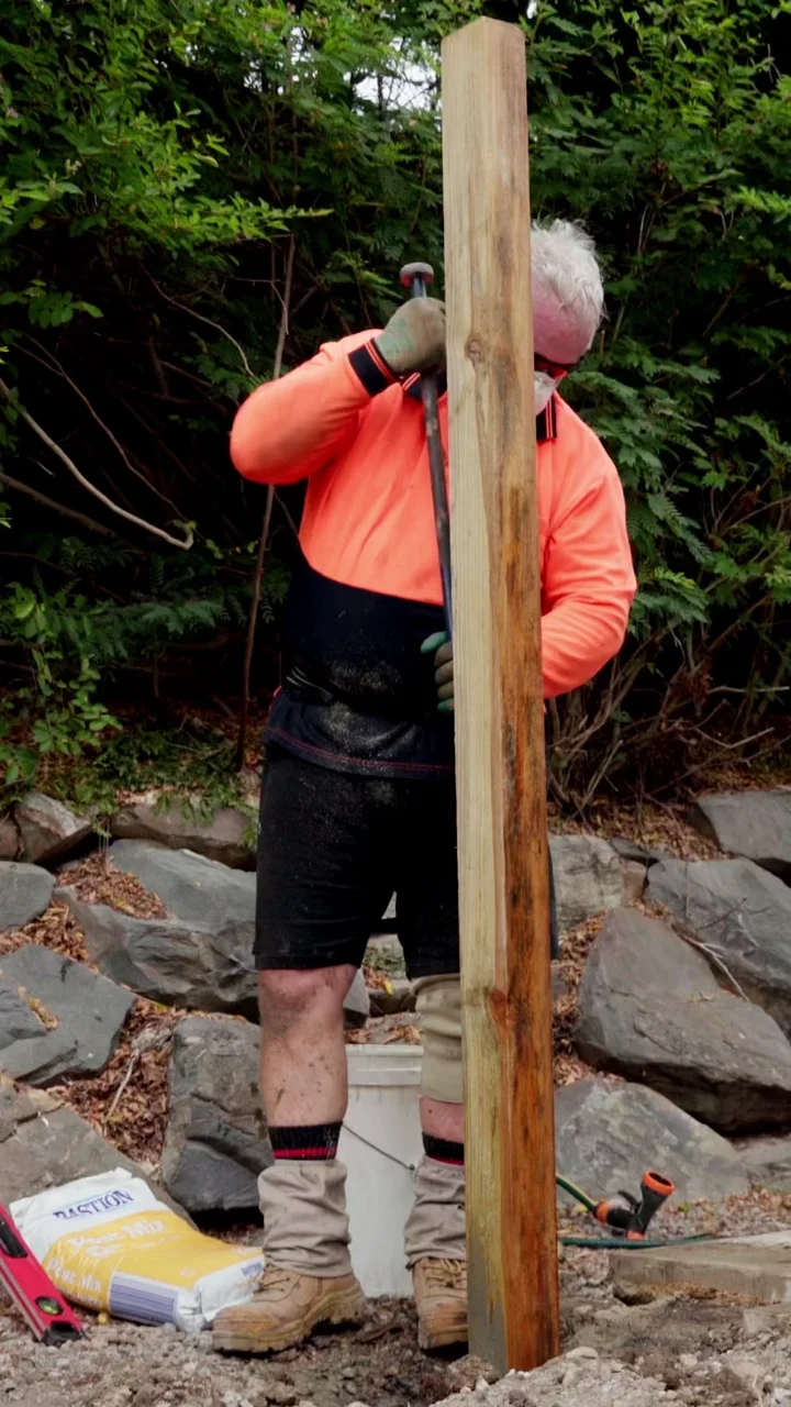 Bryce Roadley installing a treated pine fence on the Gold Coast